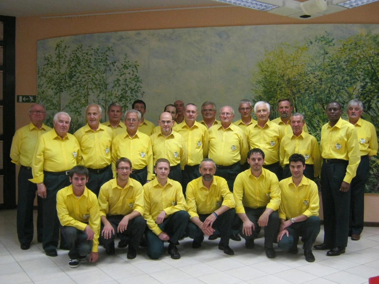 Fotografia di gruppo del Coro La Brughiera nella divisa gialla e verde