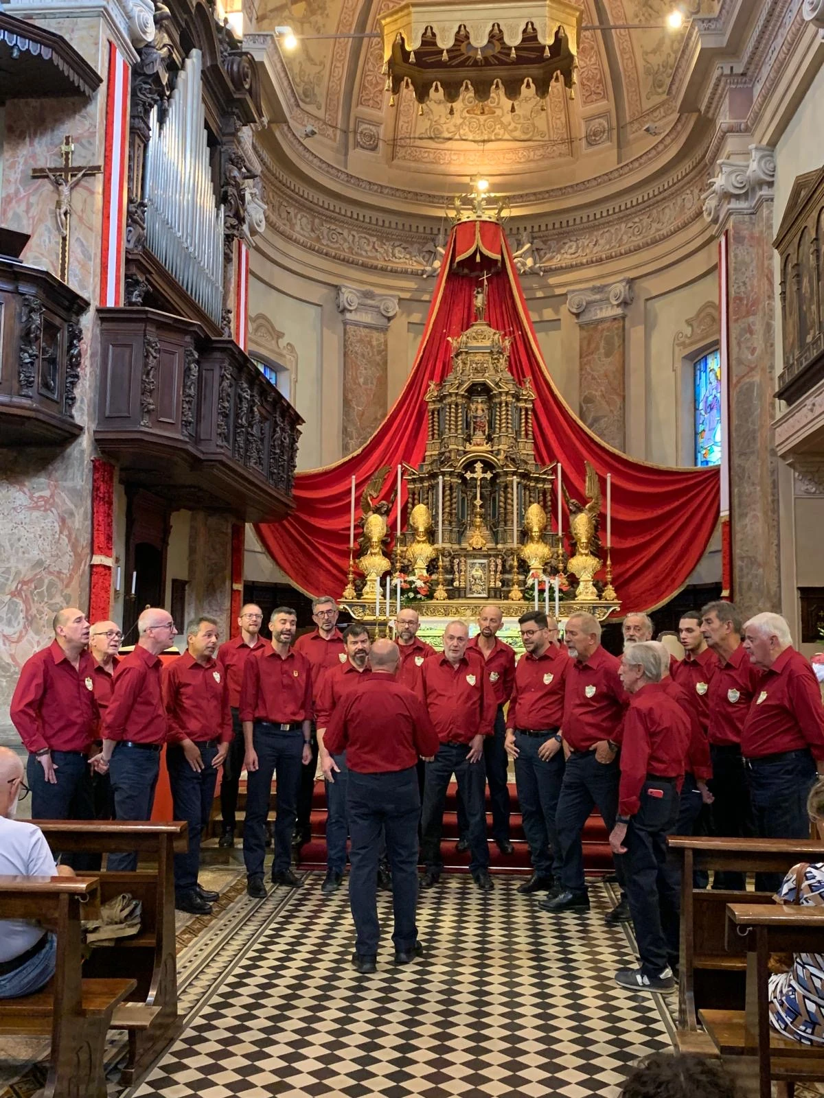 Il coro in concerto con la divisa bordeaux attuale